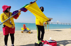Two lifeguards on a beach providing lifeguard services.
